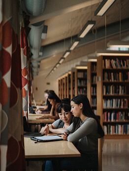 Students studying together at a table in a library.